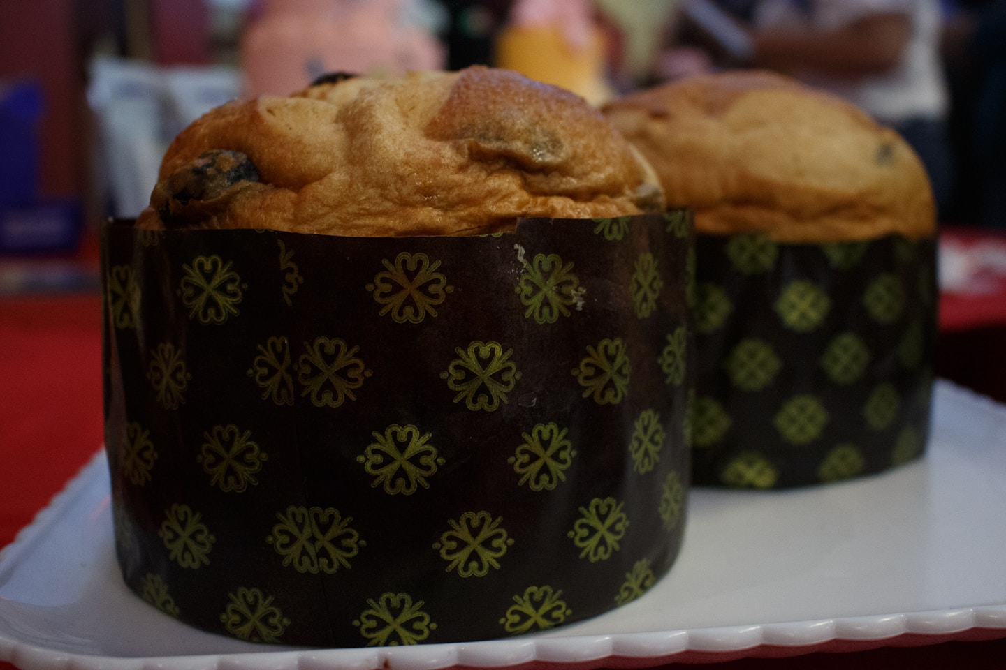 Two panettone cakes in decorative paper molds.